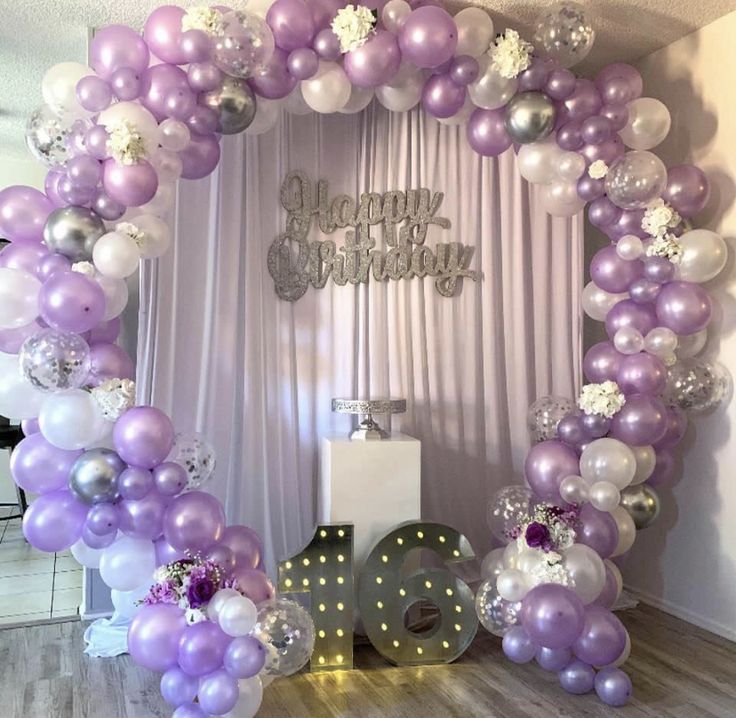 the balloon arch is decorated with purple, white and silver balloons