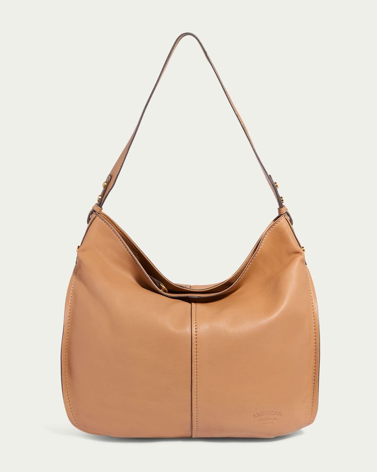 Introducing the Summit Large Top Zip Hobo by American Leather Co., an oversized hobo bag made of light brown genuine leather. This stylish bag features a single wide strap and offers a soft, slouchy design with minimal stitching detail. It includes a zippered compartment for convenience and sports a subtle embossed logo at the bottom right corner. Leather Hobo Bag With Zipper Closure For Fall, Casual Hobo Bag With Leather Lining For Travel, Casual Travel Hobo Bag With Leather Lining, Casual Hobo Bag For Travel With Leather Lining, Everyday Leather Hobo Bag With Leather Trim, Leather Hobo Bag With Zipper Closure, Casual Hobo Bag With Leather Backing For Daily Use, Casual Leather Hobo Bag With Zipper Pocket, Casual Leather Hobo Bag With Zipper