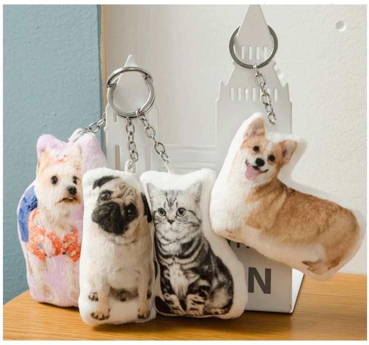 four small stuffed animals sitting on top of a keychain in front of a door