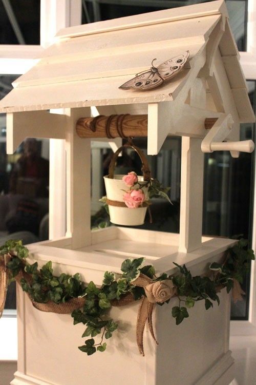 a white bird house with flowers in it