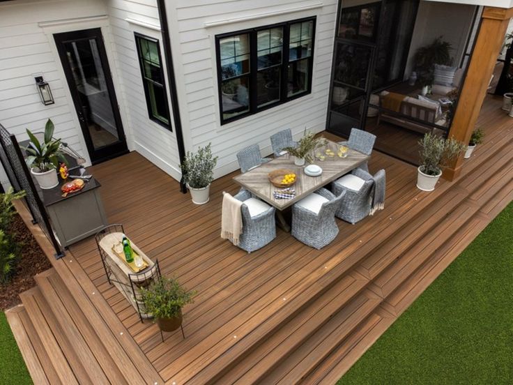 an aerial view of a deck with table and chairs, potted plants and outdoor furniture