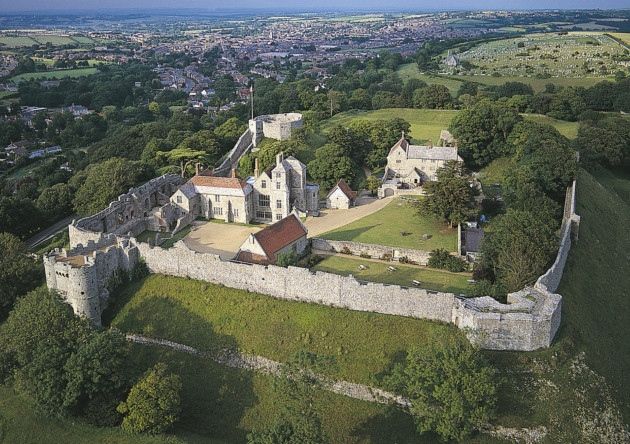 an aerial view of a castle in the middle of a green field with lots of trees