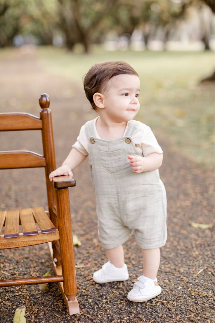 a small child standing next to a wooden chair