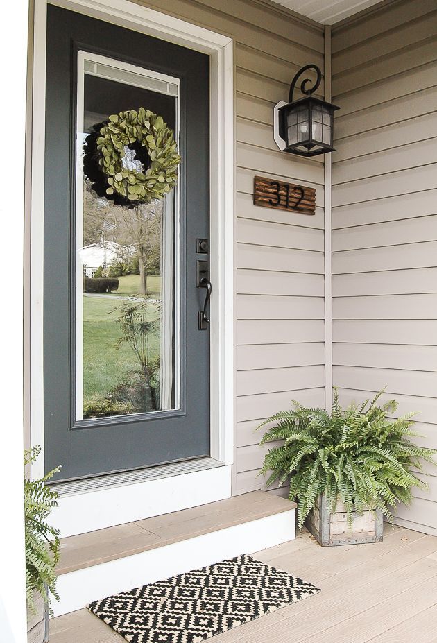 a front door with a wreath and potted plant