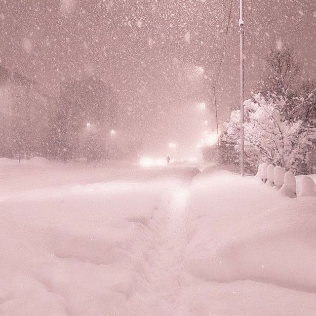 a snow covered street at night with traffic lights