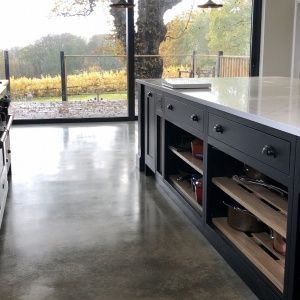 a large kitchen with an island in the middle and open glass doors leading to outside