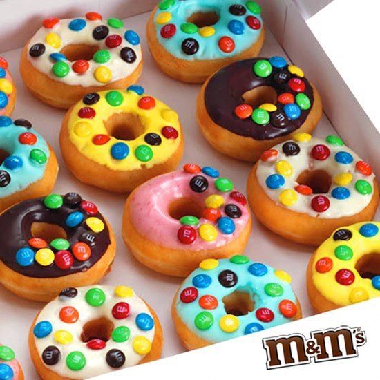 a box filled with lots of colorful donuts covered in m & m's