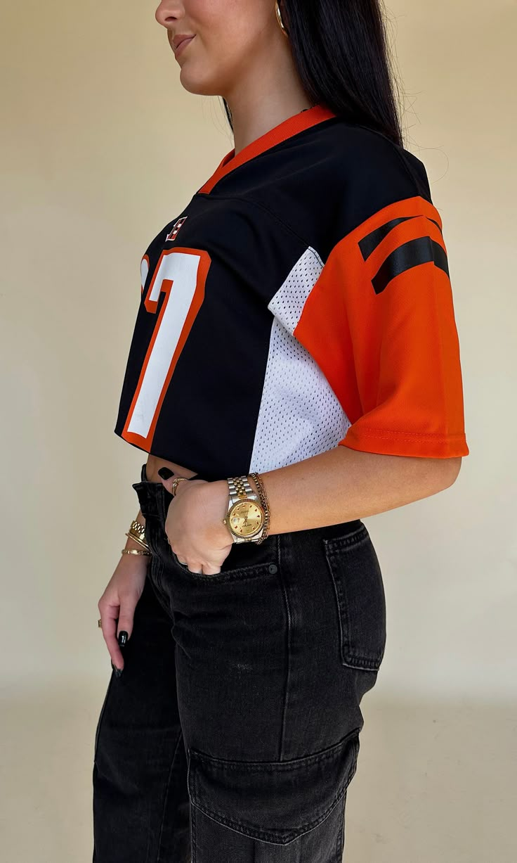 a woman wearing an orange and black football jersey