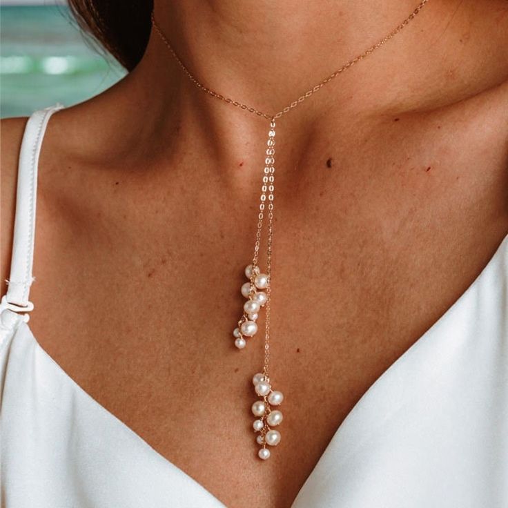 Enhance your jewelry collection with our sophisticated Pearl Drop Necklace, crafted with 14K gold filled metal and a lustrous natural freshwater pearl pendant. This elegant piece is designed to add a touch of refinement to any outfit, making it perfect for everyday wear or special occasions. ✨ Details: Metal: 14K Gold Filled Main Stone: Freshwater Pearl Pearl Type: Natural Freshwater Pearls Item Weight: Approx. 1g Style: Elegant, Simple Layering, Y Necklace, Bridesmaid Necklace This exquisite ne Gold Dangle Pearl Necklace For Party, Gold Pearl Necklace With Clavicle Chain Dangle, Gold Lariat Pearl Necklace With Pendant, Gold Pearl Lariat Necklace For Wedding, Gold Pearl Charm Backdrop Necklace, Gold Pearl Drop Backdrop Necklace, Gold Pearl Chain Backdrop Necklace, Gold Backdrop Necklace With Pearl Charm, Gold Backdrop Necklace With Pearl Drop