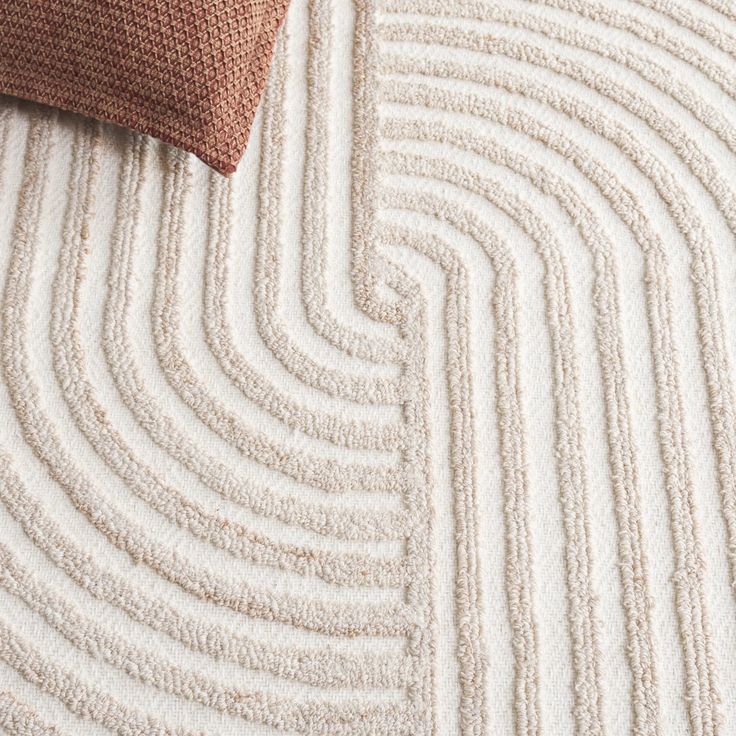 a close up view of a white and brown rug with wavy lines on the floor