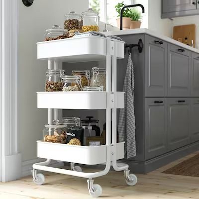 a kitchen cart filled with lots of food on top of a hard wood floor