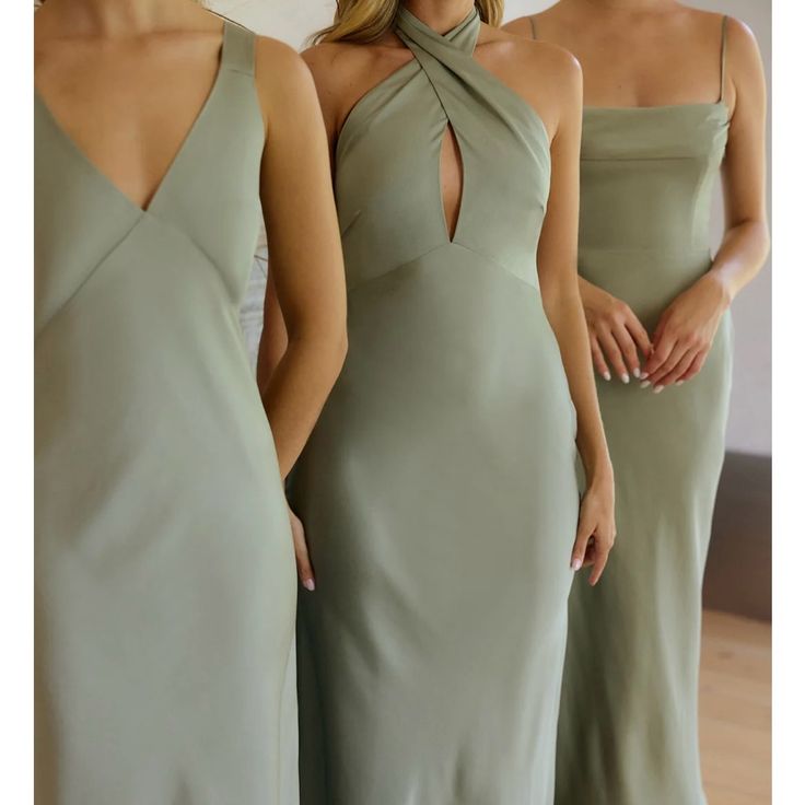 three women in long dresses standing next to each other and one is wearing a halter neck dress