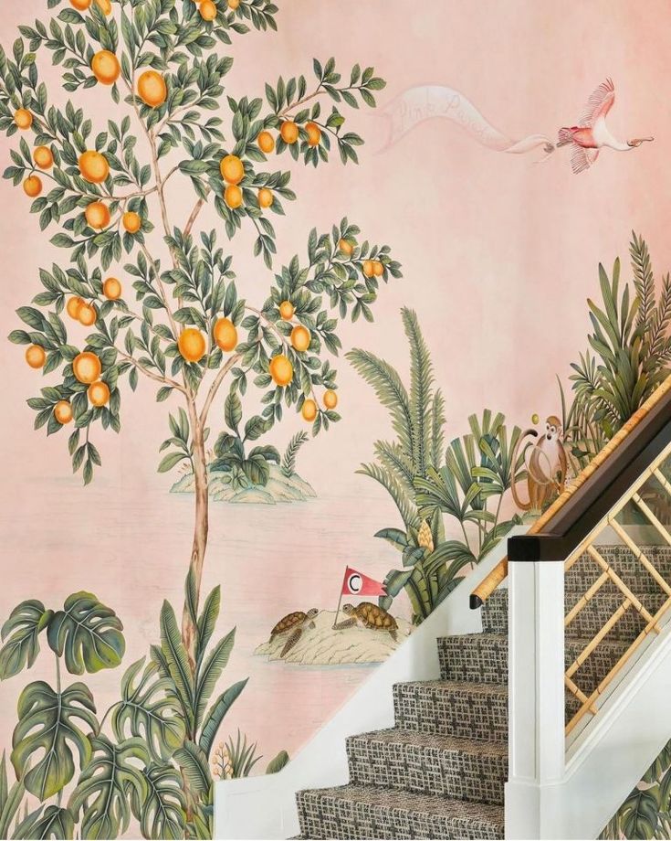 an orange tree is painted on the wall next to some stairs and handrails