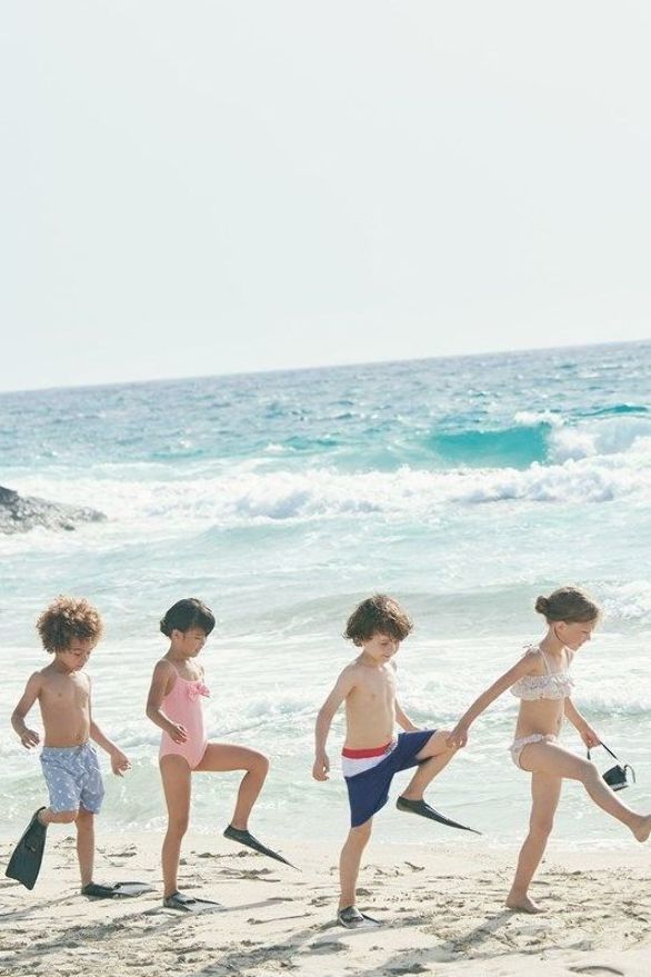 four young children are playing on the beach