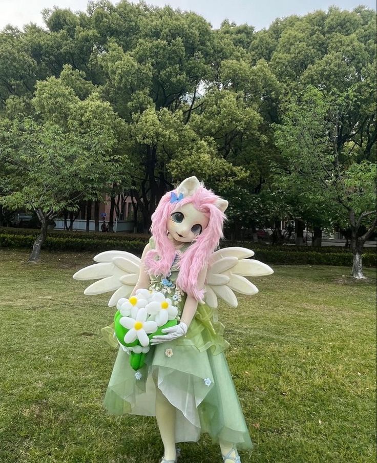 a doll dressed as a fairy holding flowers