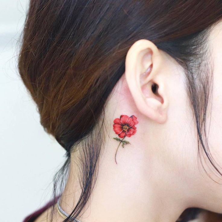 a woman with a red flower behind her ear