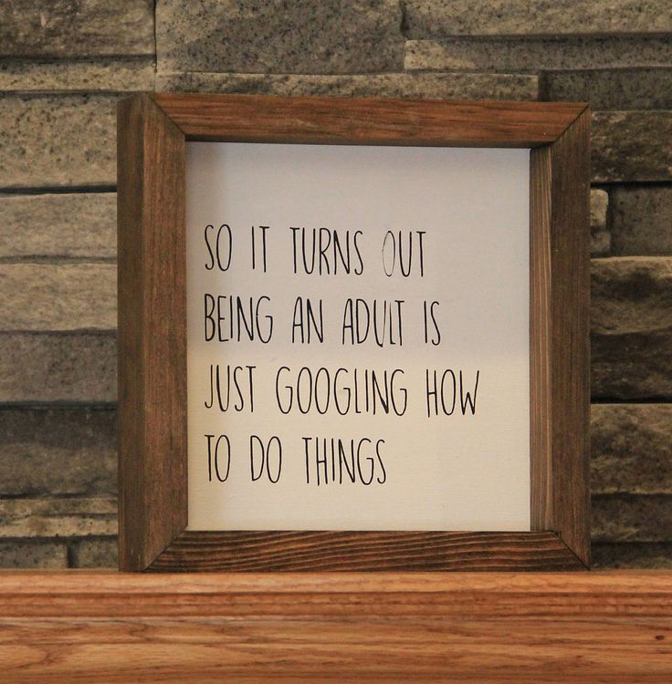 a wooden frame sitting on top of a shelf next to a brick wall with a poem written in it