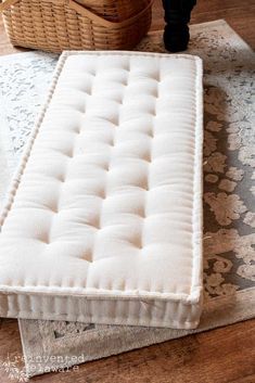 a white bench sitting on top of a wooden floor next to a basket filled with flowers