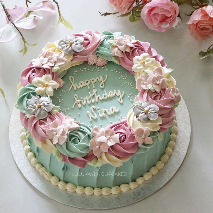 a birthday cake decorated with flowers on a table