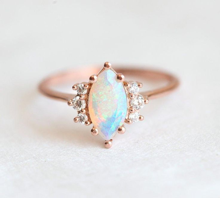 A beautiful marquise opal & diamond ring set made in 14k or 18k gold, pictured in rose gold. A perfect wedding, engagement or bridal set.
The design can be made with gemstones of your choosing.
If you would prefer a custom ring, please contact us before purchase.
Details Main stone Gemstone: Australian opal Cut: marquise Measurements: approx. 10x5mm
Side stones Gemstone: white diamonds Shape: round Measurements: approx. 2mm (2), approx. 1.5mm (4) Quality: clarity grade VS, color grade G, conflic Rose Gold Moonstone Ring, Gold Moonstone Ring, Gold Opal Ring, Rose Gold Opal Ring, Opal Diamond Ring, Ring Marquise, Opal Engagement Ring, Opal Ring Gold, Fire Opal Ring