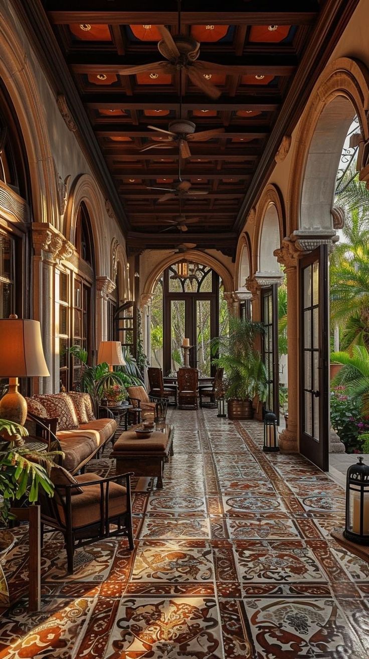 a large hallway with lots of windows and plants on the walls, along with couches and lamps