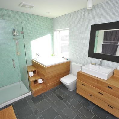 a bathroom with a sink, toilet and shower stall in the middle of it's tile flooring