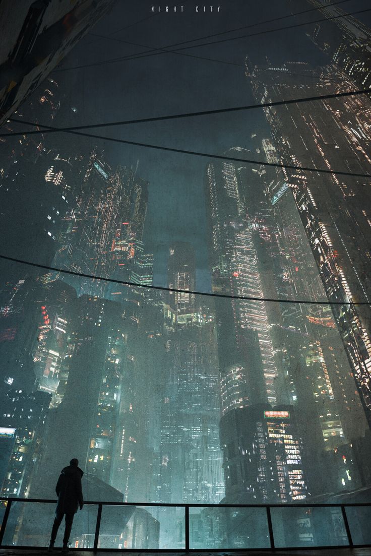 a man standing on top of a tall building in the middle of a city at night