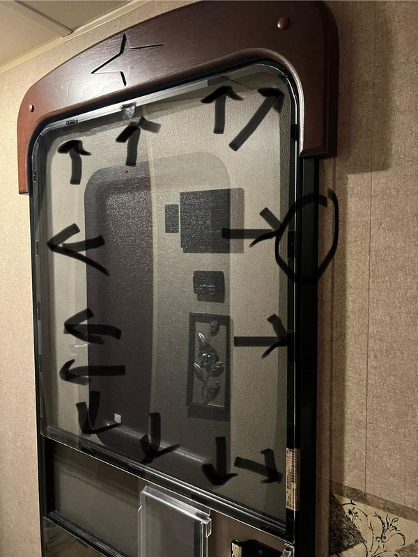 an elevator with arrows on the glass and metal frame in front of it's door