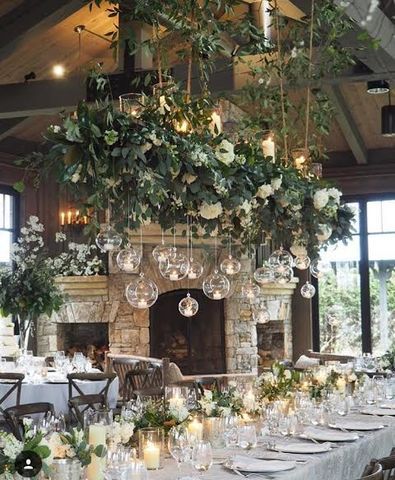 an image of a table setting with candles and greenery on the fireplace mantel