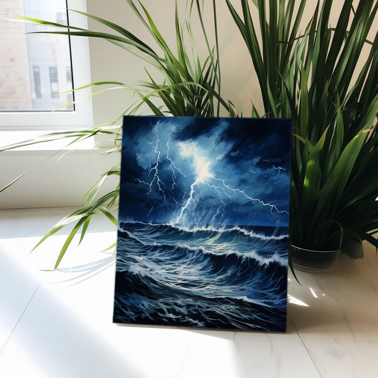 a painting on a table next to a potted plant with a green plant in it