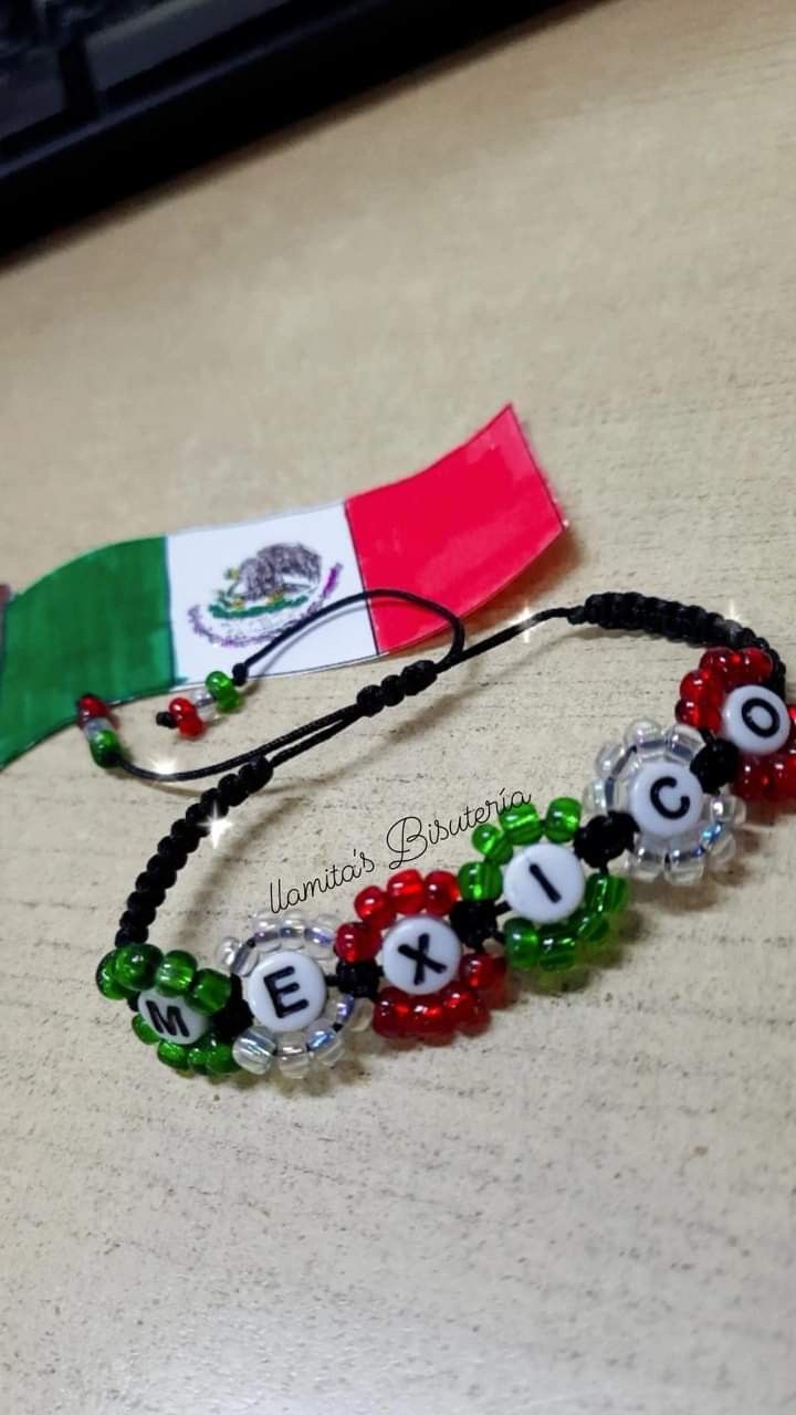 a beaded bracelet with the flag of mexico and letters on it, sitting on a table