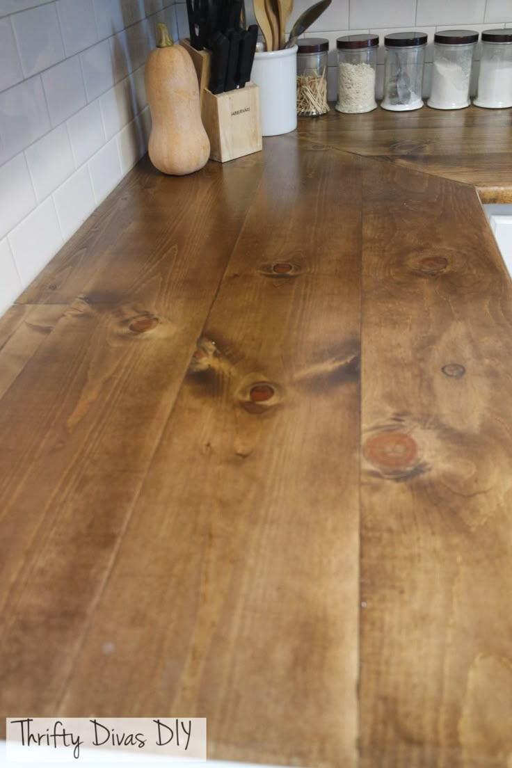 a wooden counter top in a kitchen next to a knife holder and utensils