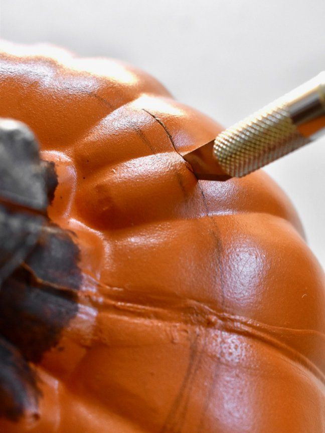 a close up of a pumpkin with a toothbrush stuck in it's mouth