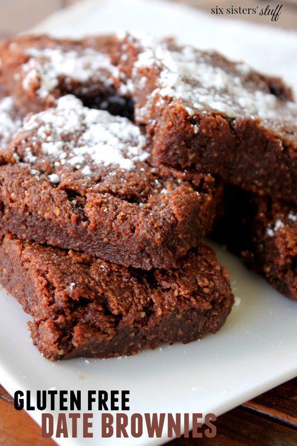 gluten free date brownies on a white plate with powdered sugar in the middle