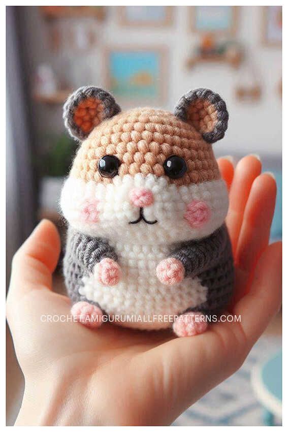 a small crocheted hamster sitting on top of someone's hand