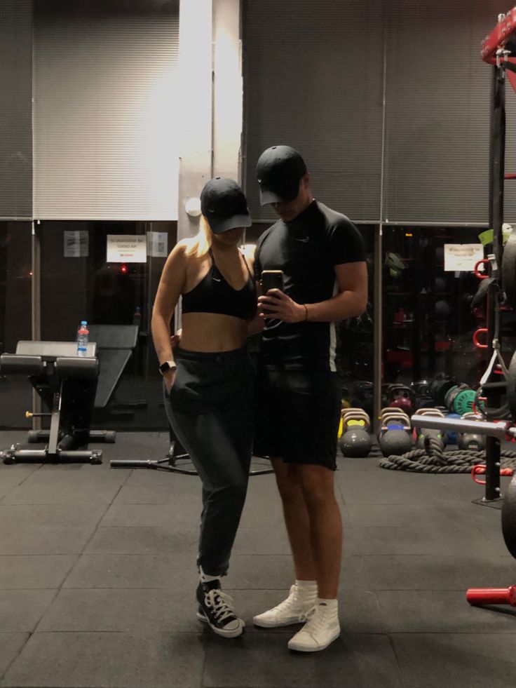 a man and woman standing next to each other in a gym