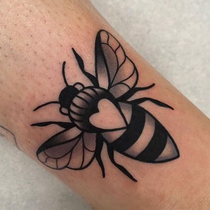 a black and white bee tattoo on the arm