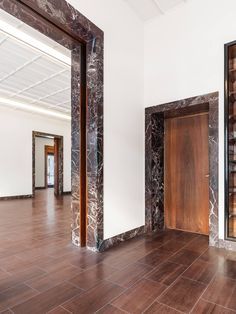 an empty room with marble walls and wooden doors