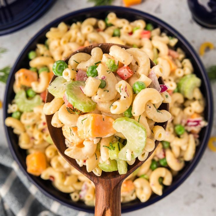 a wooden spoon filled with macaroni salad