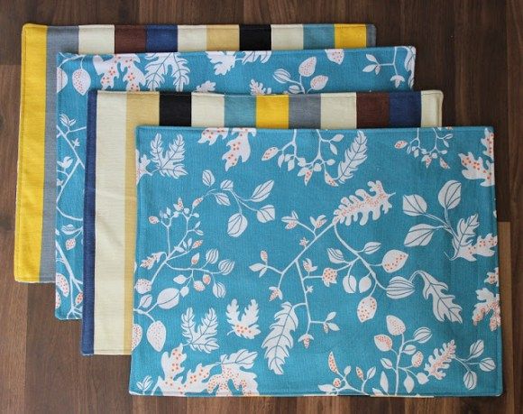 four placemats with different designs on them sitting on a wooden floor next to each other