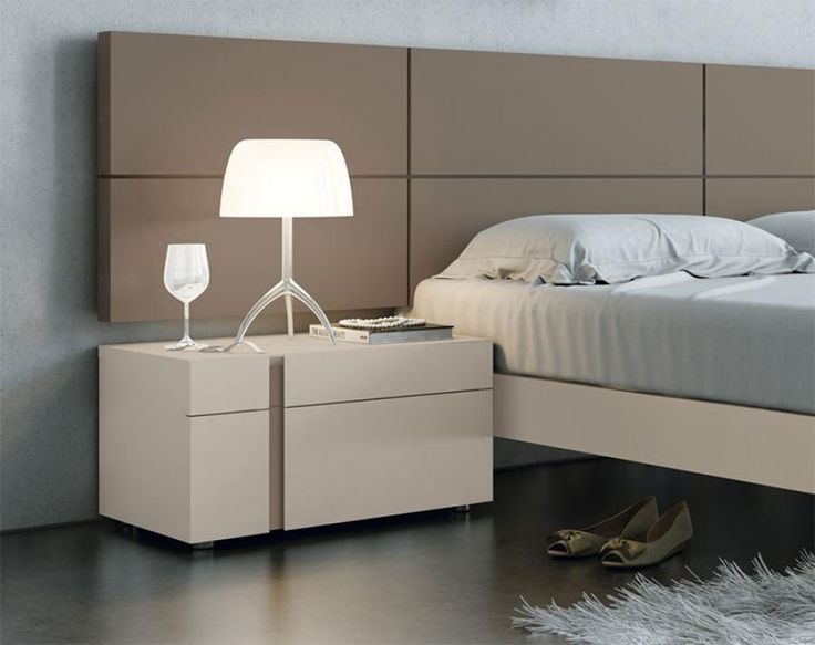 a bedroom with a bed, night stand and two glasses on the nightstand next to it