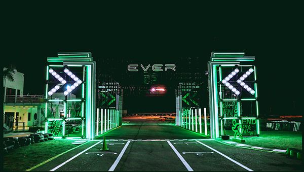 the entrance to an event lit up with neon green lights and arrows on it's sides