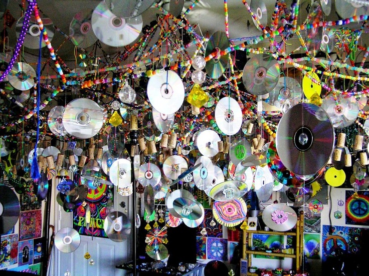 a room filled with lots of cds hanging from the ceiling next to wall mounted discs