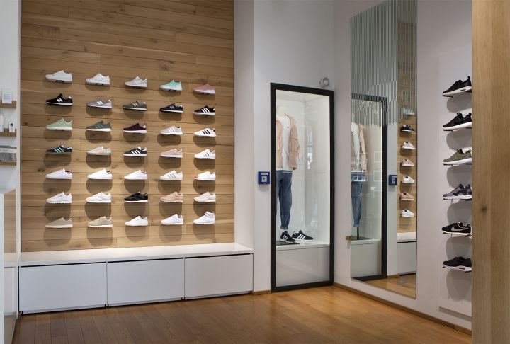 a man sitting on a bench in front of a display of shoes