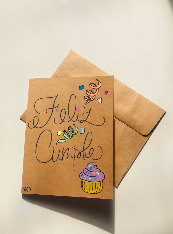 two brown envelopes with writing on them and a cupcake drawn on the front