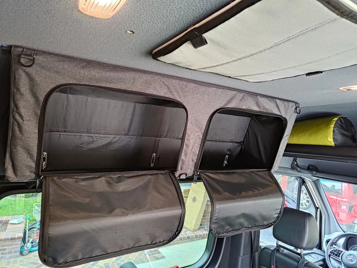 the interior of a vehicle with luggage in it's back pocket and windows open