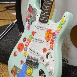 an electric guitar with many stickers on it