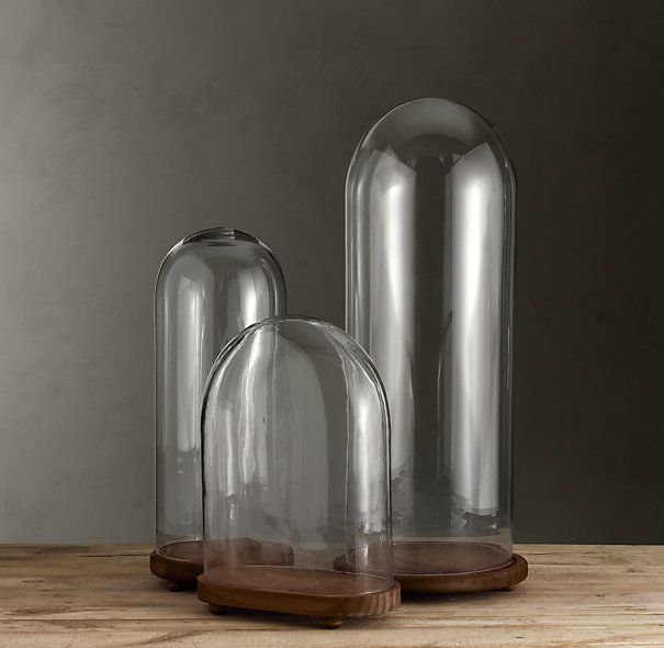 two clear glass vases sitting on top of a wooden table next to each other