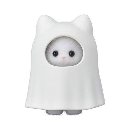 a white cat toy with black eyes and a ghost cape on it's head