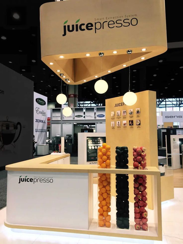 the juicepresso stand at an event with fruit hanging from it's ceiling